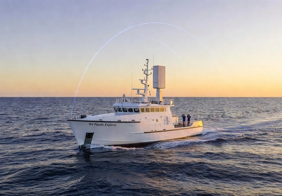 A modern white research vessel sailing across the deep blue open Pacific Ocean at golden hour dawn, with a sleek flat-panel satellite internet terminal mounted prominently on the mast, glowing blue orbital trajectory arcs visible in the pale morning sky above connecting the ship to multiple satellites, photorealistic cinematic lighting, wide-angle shot emphasizing the vastness of the ocean and the smallness yet technological sophistication of the vessel