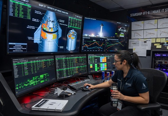 A female aerospace engineer with dark hair tied back sits at a curved multi-monitor workstation inside a dimly lit SpaceX-style control room, her face illuminated by cascading green and blue telemetry data streams, Starship structural diagrams visible on the largest central screen, photorealistic, cinematic lighting, ultra-detailed, futuristic but grounded in real technology, wide angle shot